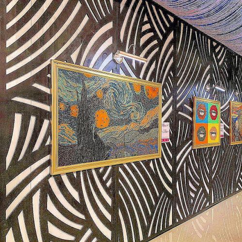 A gallery wall featuring "Starry Night" framed, surrounded by abstract patterned wallpaper and other artworks.