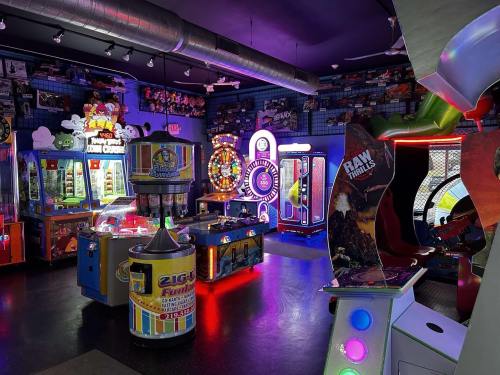 A vibrant arcade filled with colorful games, neon lights, and various arcade machines in a fun atmosphere.