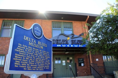 Sign for the Delta Blues Museum in Clarksdale, Mississippi, with the museum's entrance visible in the background.