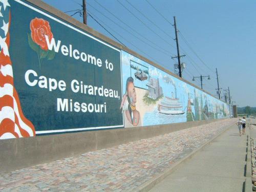 Mural welcoming visitors to Cape Girardeau, Missouri, featuring local history and culture along a stone pathway.