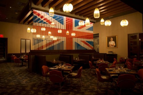 Interior of a restaurant featuring a large Union Jack mural, stylish seating, and warm pendant lighting.