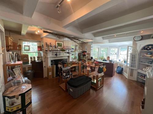 A cozy shop interior with wooden shelves, various products, and large windows letting in natural light.