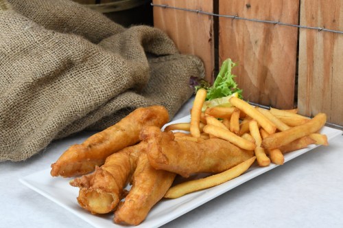 A plate of golden fried fish fillets and crispy French fries, garnished with a small piece of lettuce.