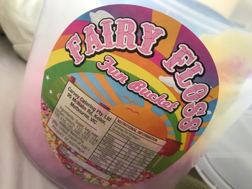 A colorful container labeled "Fairy Floss Fun Bucket" with a rainbow design and nutritional information on the side.