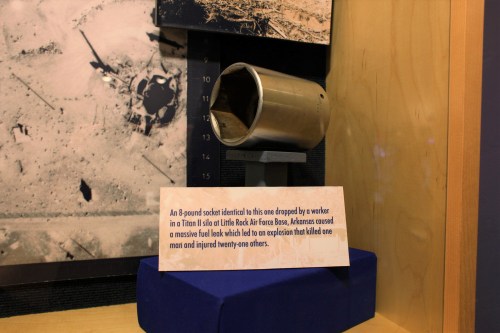 A metal socket displayed in a museum, with a sign explaining its connection to a historical incident at Little Rock Air Force Base.