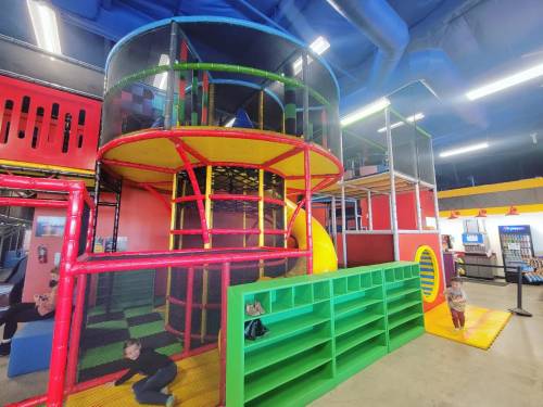 Colorful indoor playground with climbing structures, slides, and play areas for children.