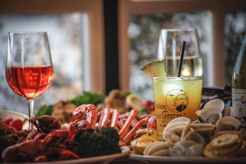 A table set with seafood, including crab and clams, alongside drinks in elegant glasses.