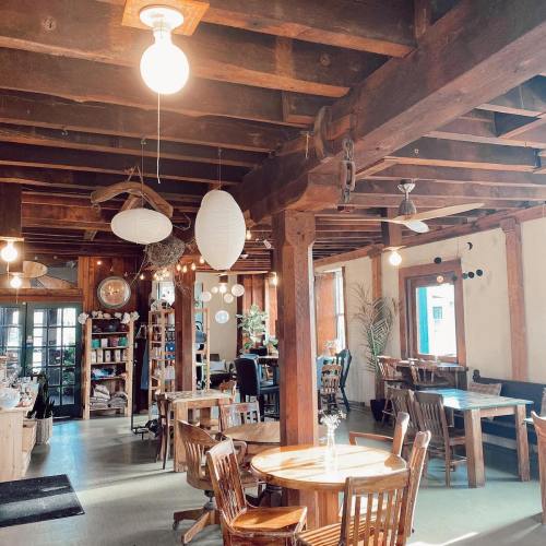 Cozy café interior with wooden beams, tables, and soft lighting, creating a warm and inviting atmosphere.