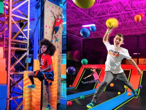 Kids enjoying an indoor adventure park, climbing a wall and jumping on trampolines with colorful balls flying around.