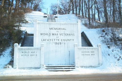 A snowy memorial honoring World War veterans of Lafayette County, featuring steps and inscriptions for various wars.