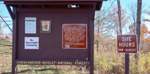 Signboard at Chequamegon-Nicolet National Forest with information on camping, site hours, and park rules.
