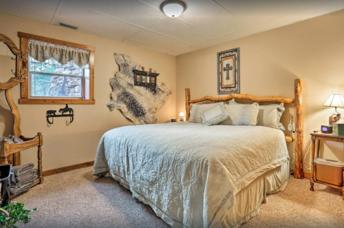 Cozy bedroom with a log bed, soft bedding, rustic decor, and a window letting in natural light.
