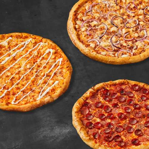 Three pizzas on a dark surface: one with pepperoni, one with red onions and chicken, and one with a creamy drizzle.