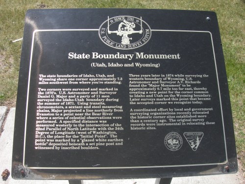 A historical plaque detailing the state boundary monument between Utah and Wyoming, established in 1876.