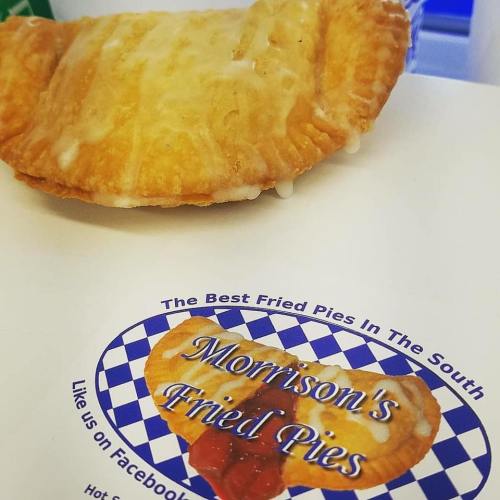 A golden fried pie sits on a white box with a logo for Morrison's Fried Pies, featuring a colorful design.