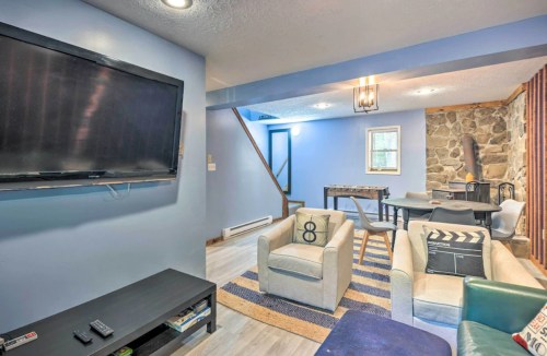 Cozy living area with a TV, light blue walls, stone accent wall, and comfortable seating.