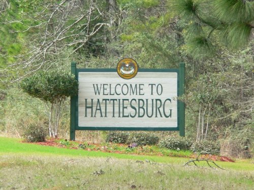 Welcome sign for Hattiesburg, featuring greenery and a decorative emblem above the text.