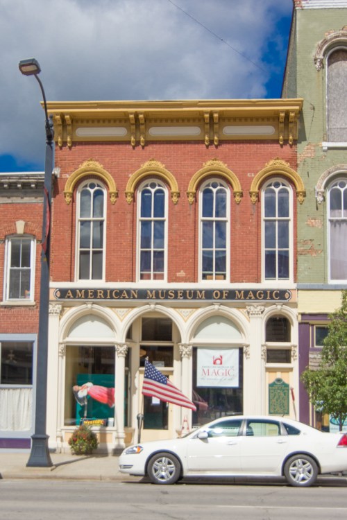 Front view of the American Museum of Magic, featuring a red brick facade and an American flag in front.