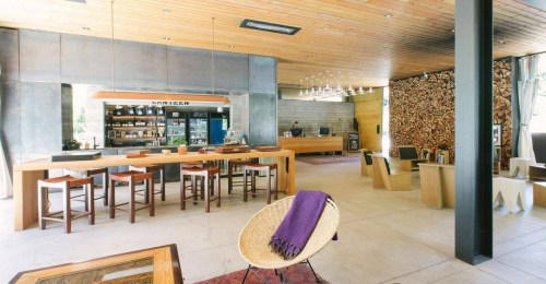 Modern interior of a café with wooden accents, a bar area, and a cozy seating arrangement.