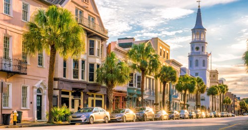 Buildings in Charleston, South Carolina, and palm trees on a sunny day.