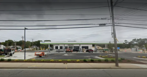 A new gas station under construction, with equipment and vehicles on-site, surrounded by a partially paved area.