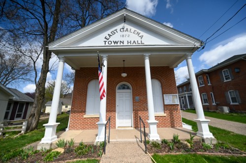Historic East Galena Town Hall, built in 1872, featuring a classic façade and American flag in front.