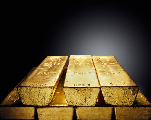 Three gold bars stacked on top of each other, gleaming against a dark background.