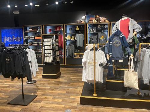 A Harry Potter merchandise store display featuring clothing, accessories, and themed items on shelves and racks.