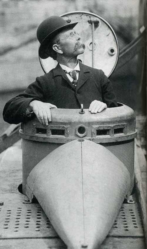 A man in a bowler hat sits in a vintage submarine, looking upward with a thoughtful expression.