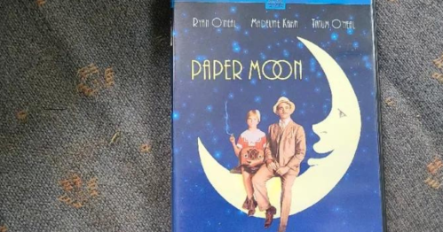 DVD cover of "Paper Moon" featuring a girl and a man sitting on a crescent moon against a starry background.
