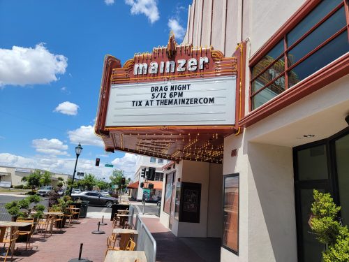 The Mainzer theater marquee announces "Drag Night" on 5/12 at 6 PM, with ticket info displayed.