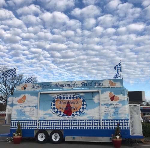 A food truck named "Morrison's Homemade Fried Pies" with a blue and white design, set against a cloudy sky.
