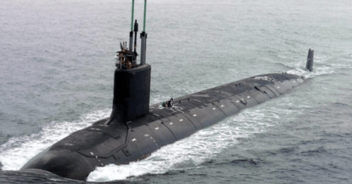 A black submarine emerges from the water, with crew members visible on top, surrounded by waves.