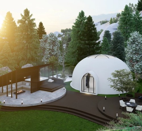 A modern dome-shaped house surrounded by trees, with a patio and outdoor seating area, set in a scenic landscape.