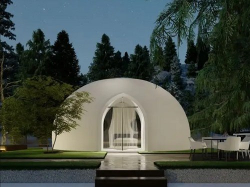 A modern dome-shaped structure surrounded by trees, featuring a glass entrance and outdoor seating area.