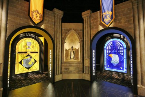 Stained glass windows representing Hufflepuff and Ravenclaw houses in a castle-like setting.