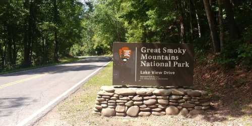 Sign for Great Smoky Mountains National Park on Lake View Drive, surrounded by trees and a winding road.