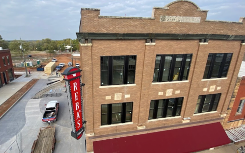 A brick building with a large red sign reading "REBAS" and a construction area nearby.
