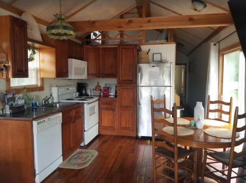 Cozy kitchen with wooden cabinets, a dining table, and modern appliances in a rustic setting.
