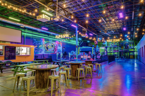 A vibrant indoor entertainment space with colorful lights, seating areas, and attractions for kids and families.
