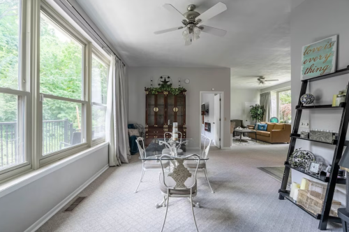 Bright, spacious living area with large windows, a dining table, and cozy seating in a modern home.
