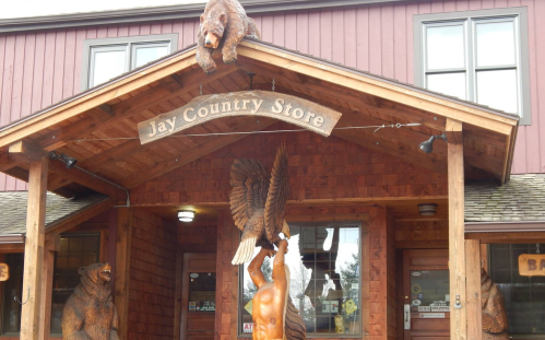Entrance of Jay Country Store featuring wooden bear carvings and a large eagle sculpture above the door.