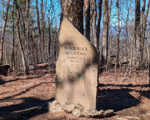 Stone monument marking Black Rock Mountain, elevation 3,640 feet, surrounded by trees in a wooded area.