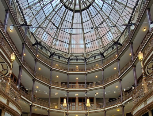 A stunning view of a glass-domed atrium with intricate architecture and elegant lighting.