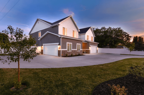 A modern two-story house with a spacious driveway and landscaped yard, set against a twilight sky.