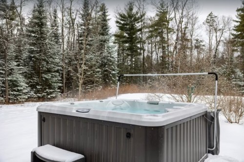 A hot tub surrounded by snow-covered trees in a winter landscape.