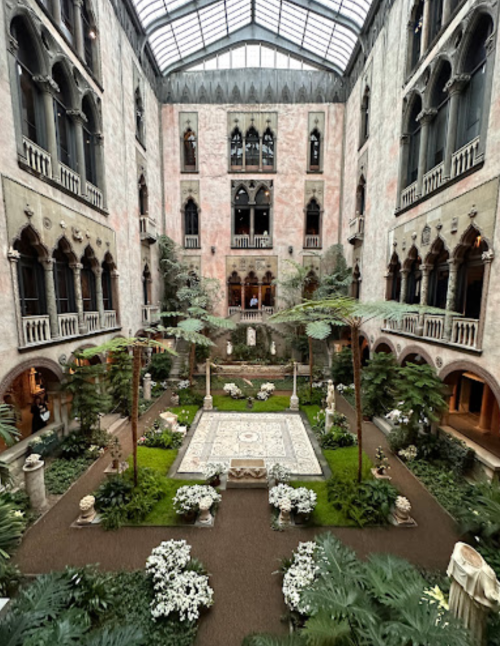 A grand indoor garden with lush greenery, sculptures, and a central mosaic, surrounded by ornate architecture.