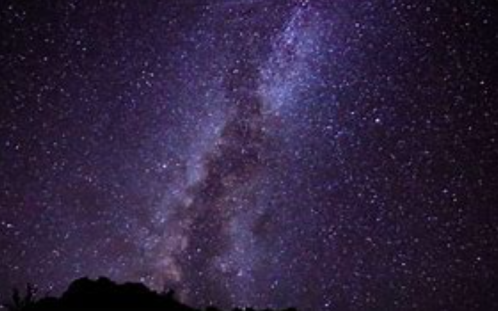 A stunning view of the Milky Way galaxy against a dark night sky, with stars twinkling brightly.