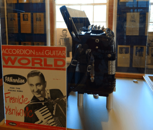 A display featuring an accordion and a magazine cover with a photo of Frankie Yankovic, the Polka King.