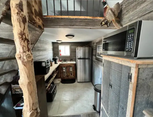 Cozy kitchen with wooden accents, stainless steel appliances, and a spiral staircase leading to an upper level.